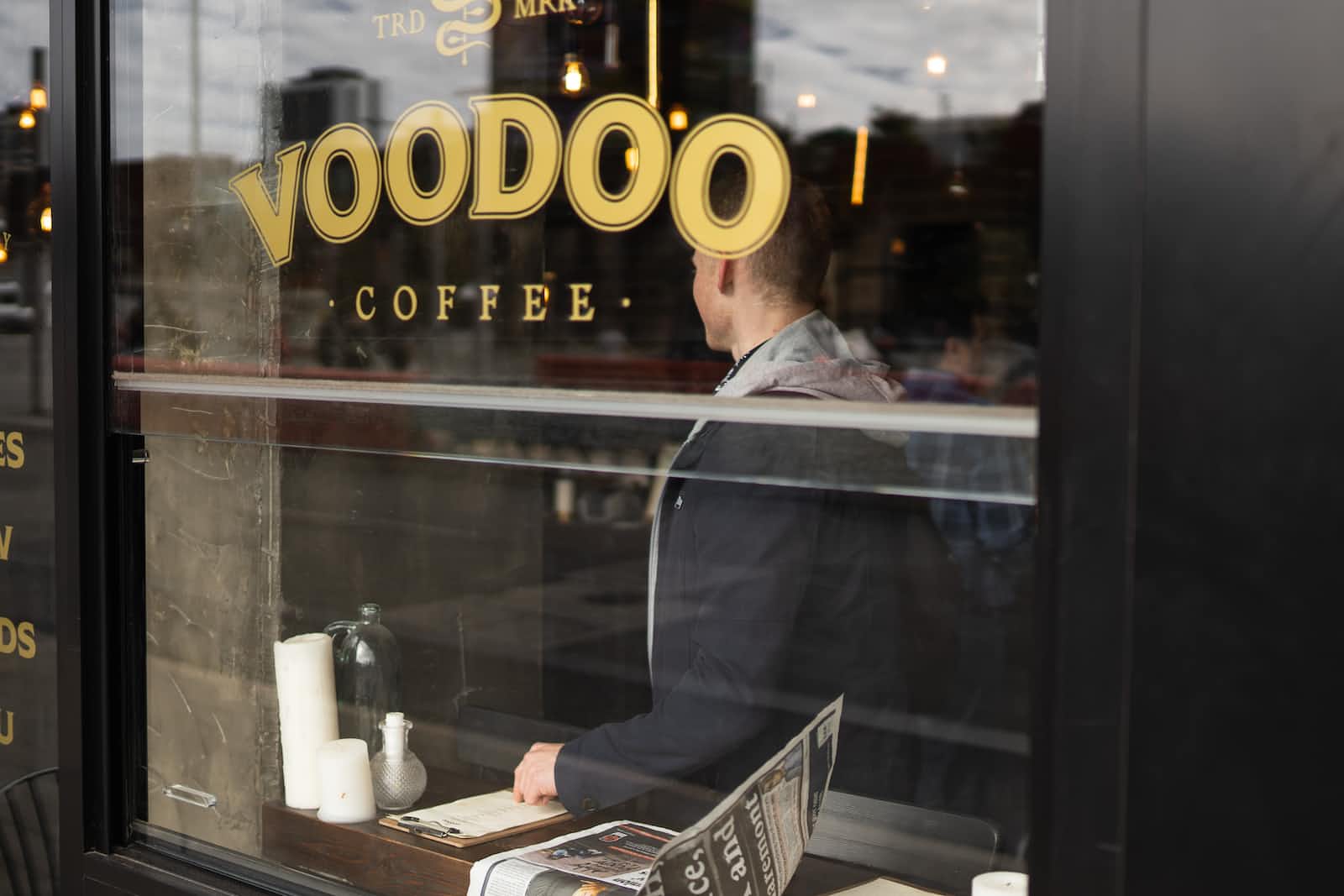 A shopfront window with the trademark name Voodoo Coffee in gold lettering