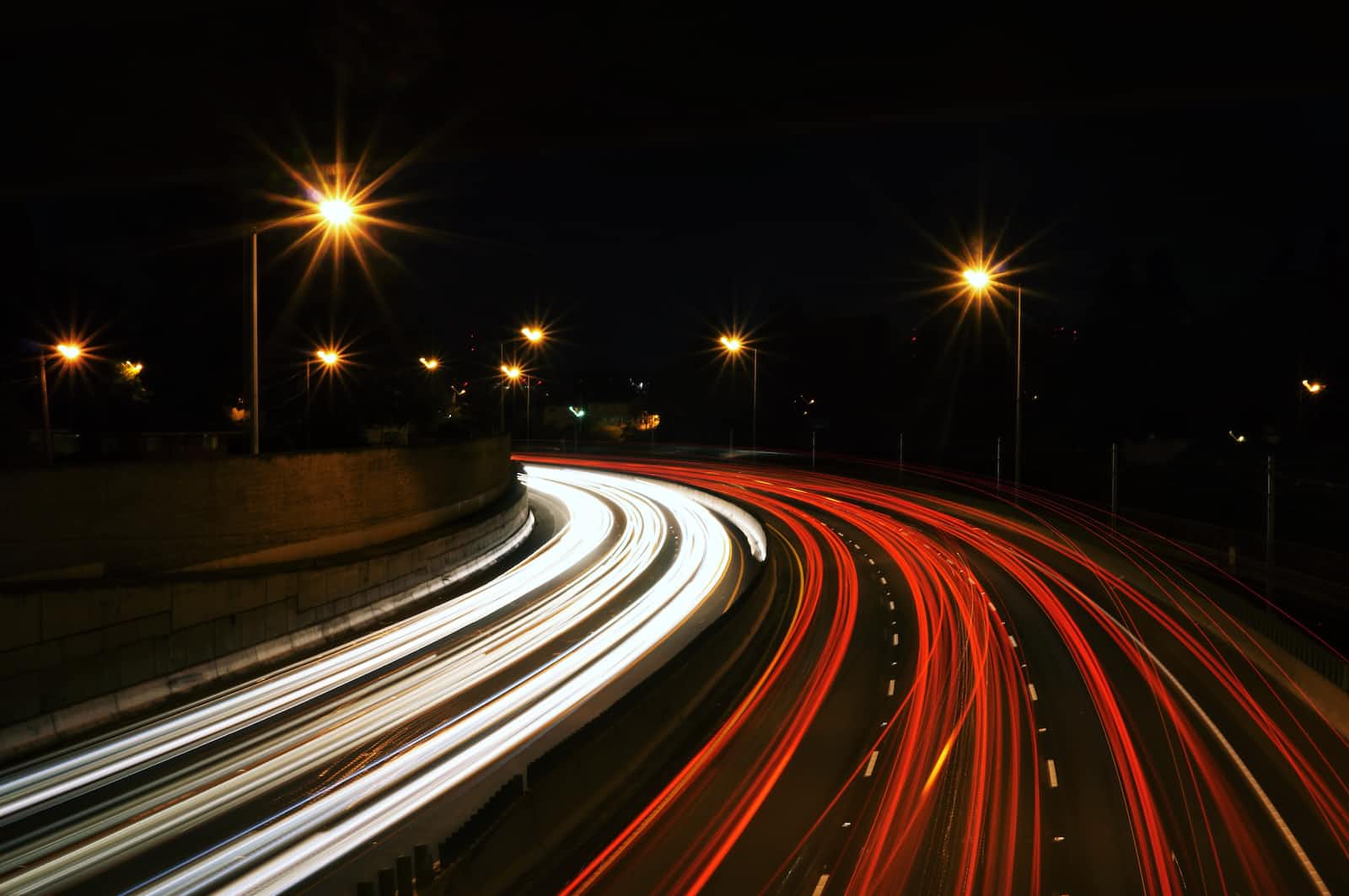 A timelapse photo of a highway showing speeding vehicles