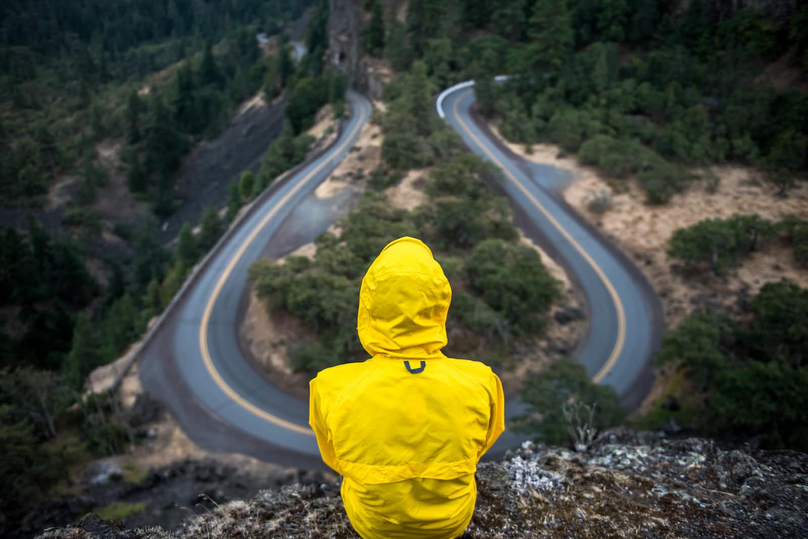 Man in yellow raincoat deciding which path to take