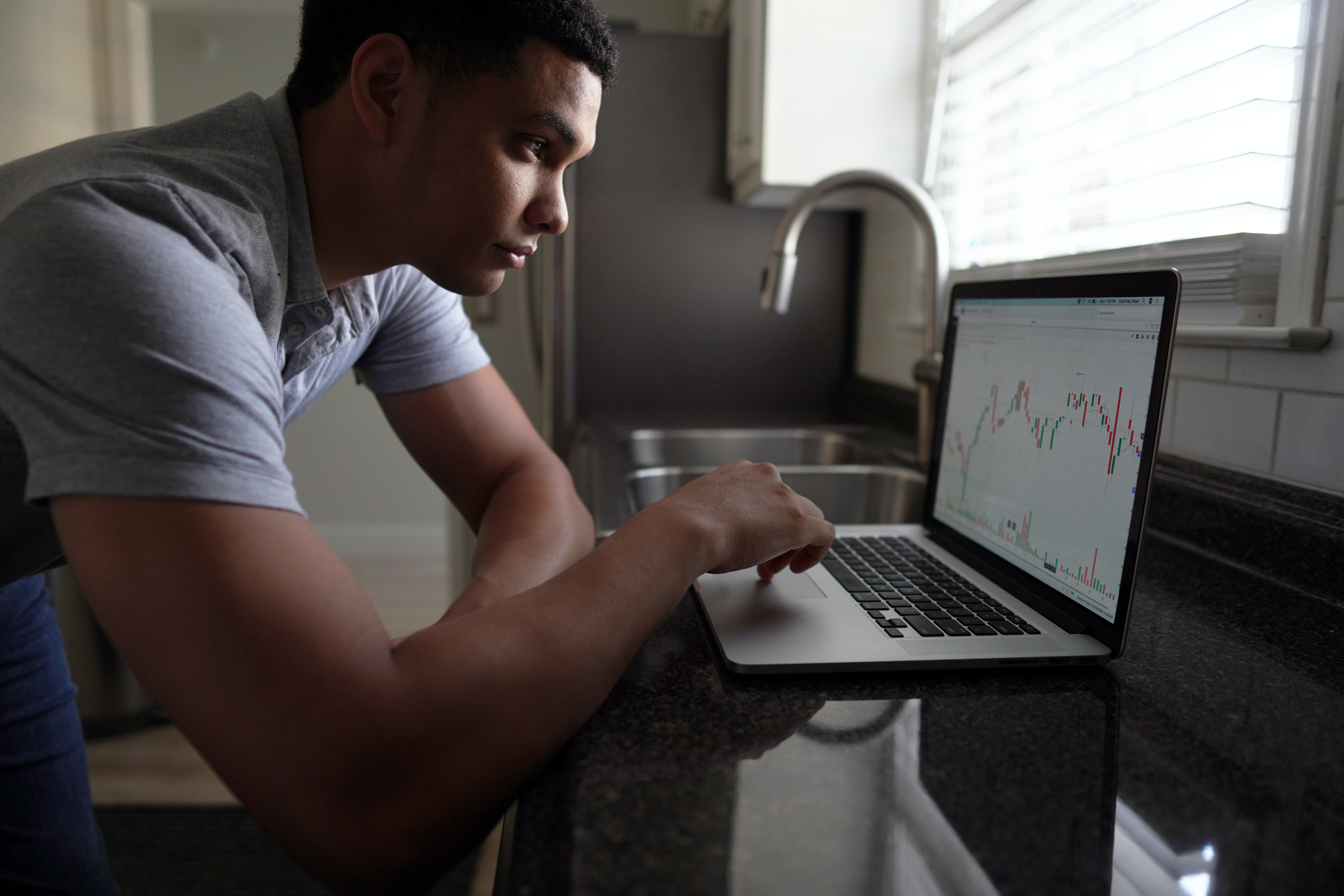 A man working on his laptop computer searching for trademarks