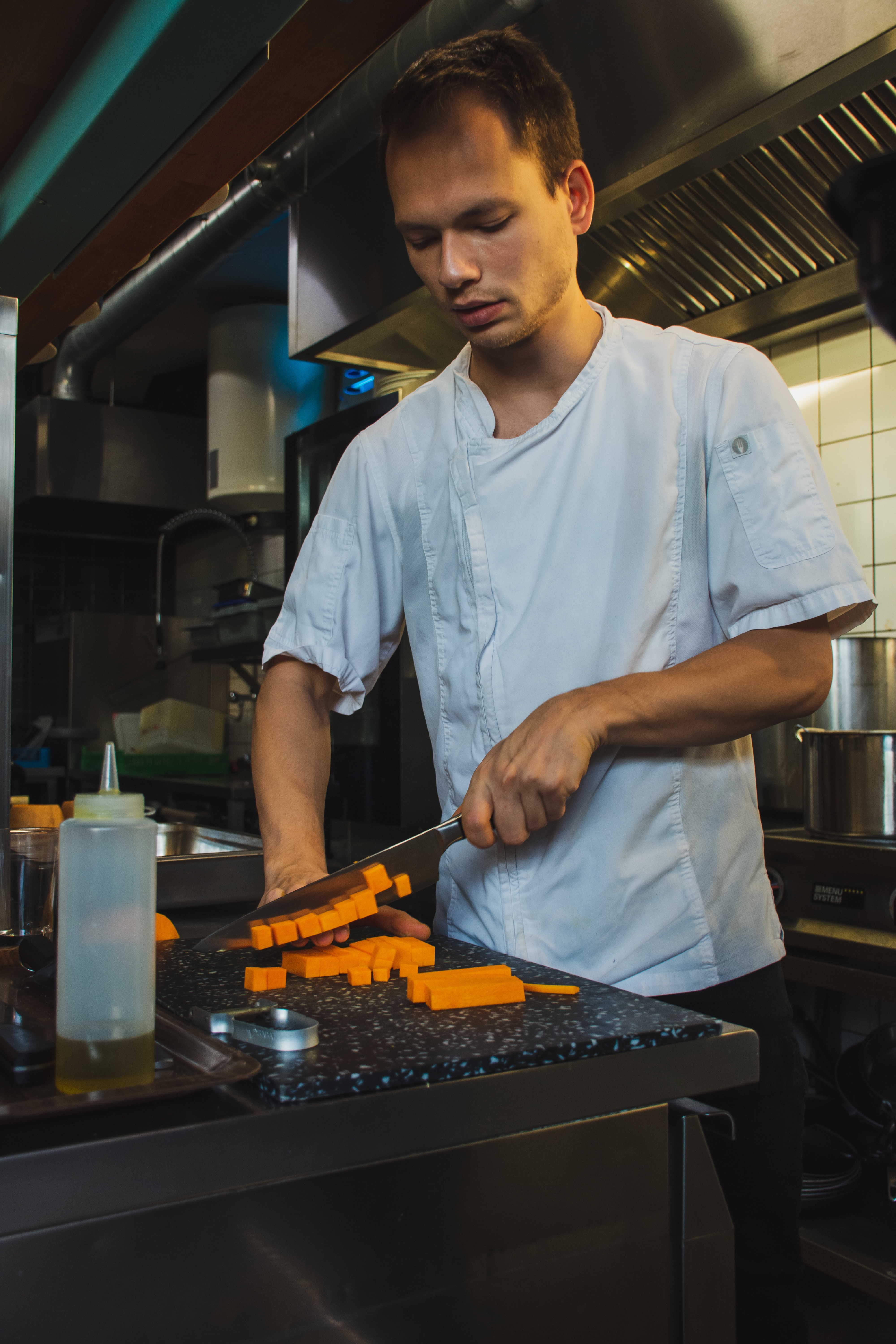 Chef cutting carrots in kitchen